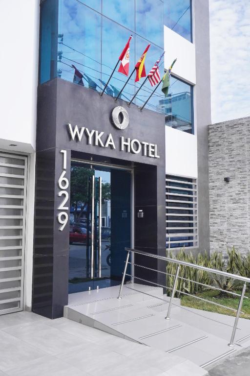 a hotel with a sign on the front of a building at Wyka Hotel in Trujillo