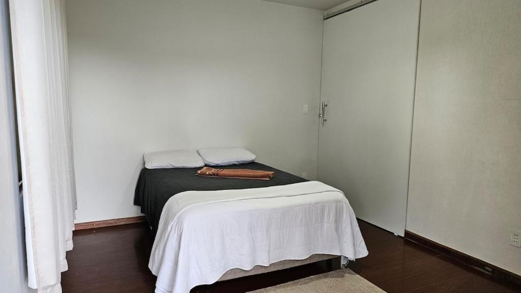 a small bedroom with a bed in a room at Quarto casal coliving 2 in Dourados