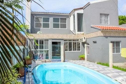 a house with a swimming pool in front of a house at Refúgio Vida & Brisa in Pelotas