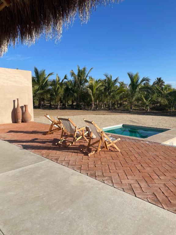 two lounge chairs sitting next to a swimming pool at Proyecto Palmita in El Pescadero