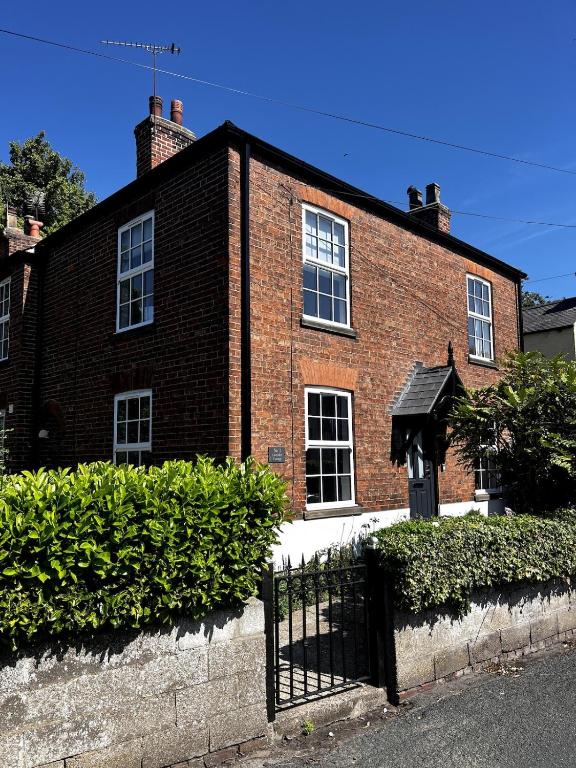 a brick house with a black fence in front of it at Lavender Cottage, Welton in Welton