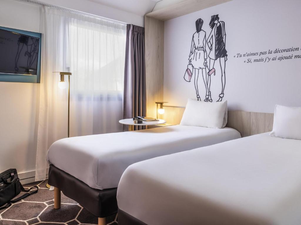 - 2 lits dans une chambre d'hôtel avec un dessin mural dans l'établissement ibis Styles Sceaux Paris Sud, à Sceaux
