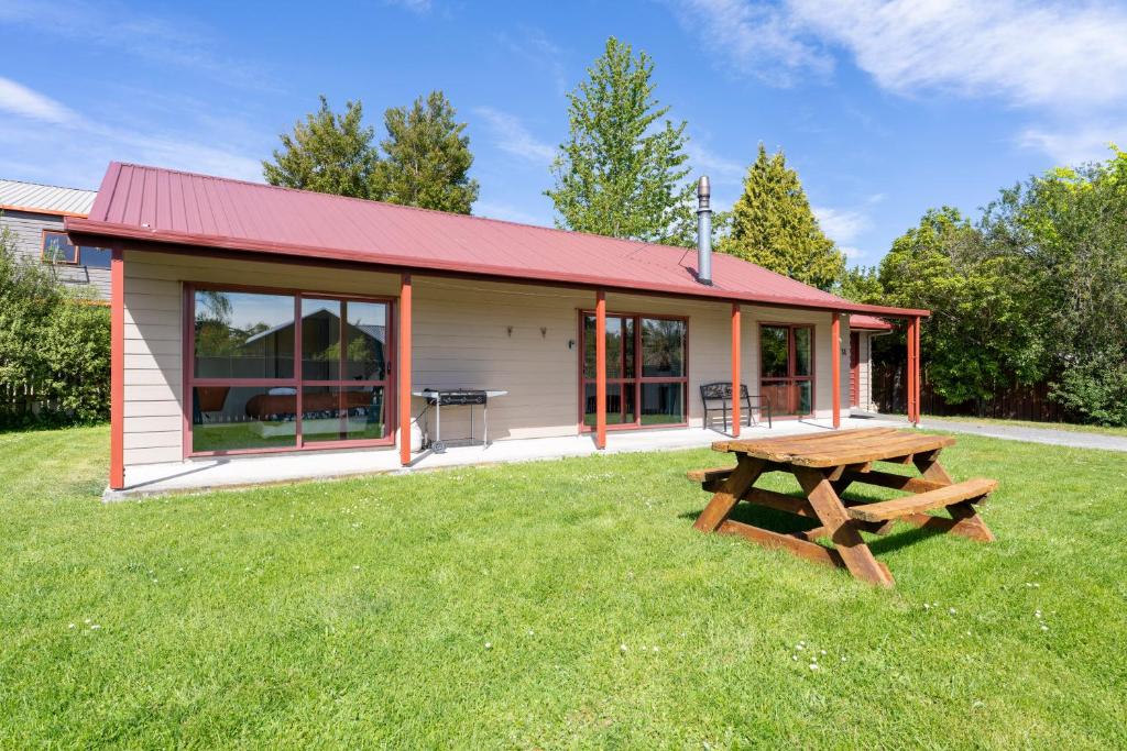 a cabin with a picnic table in the grass at Cozy, Functional,Private - HS65214 in Hanmer Springs