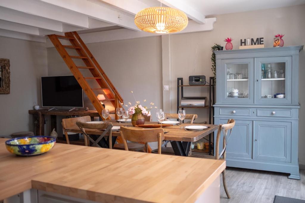 a dining room with a table and chairs and a staircase at Maison Harmonie entre Ocean et Nature in Saint-Jean-de-Monts