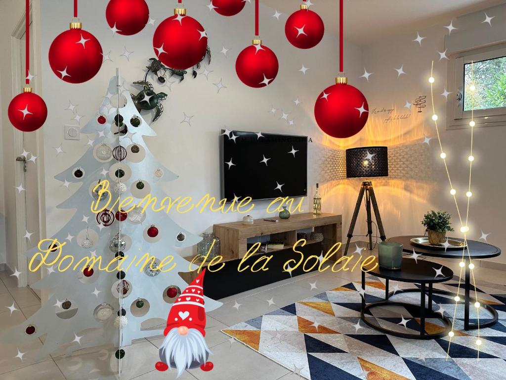 a christmas tree in a living room with red decorations at * Domaine de la Solaie * - Proche Bords de Loire in Saint-Denis-de lʼHôtel