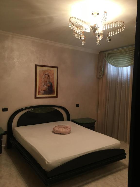 Un dormitorio con una cama y una lámpara de araña en Brodolini, en San Donato di Lecce