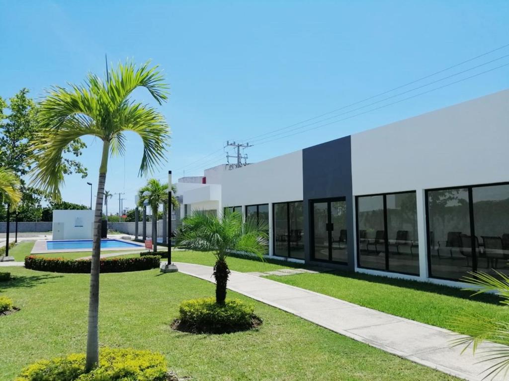 a palm tree in front of a building at Departamento Moderno Azul Cielo - 2 Albercas - 3 Min Malecón y Playas in Mazatlán