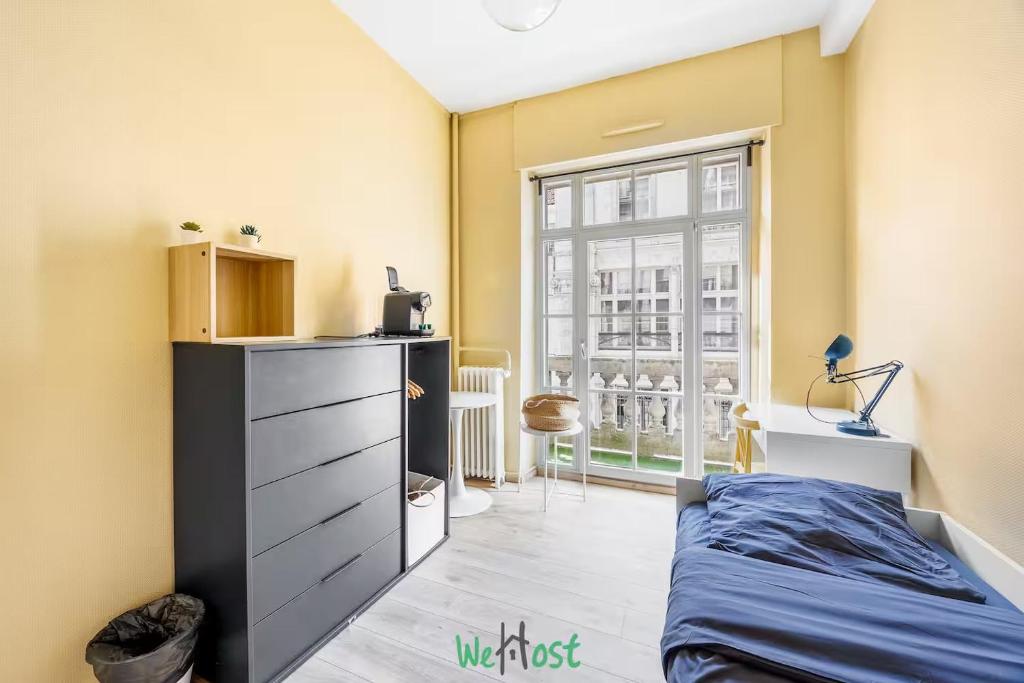 Un dormitorio con una cama y una ventana grande en COMM - Proudhon 6 - SC - Séjour moderne à Besançon, en Besançon