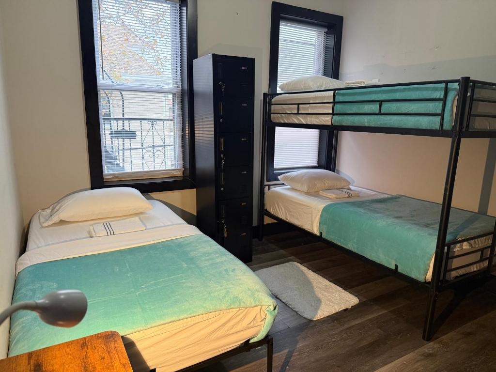 a room with two bunk beds and a window at Oasis de comodidad Habitación individual o compartida in Jersey City