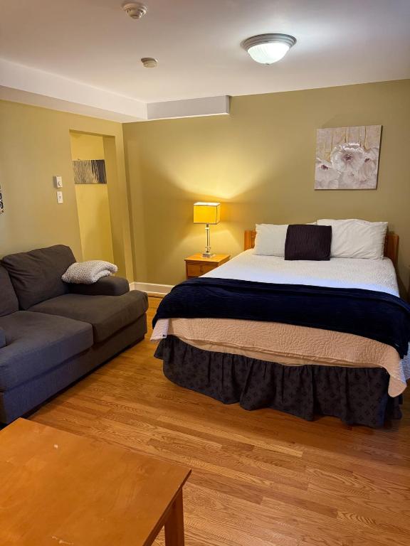 a bedroom with a large bed and a couch at Midstream Manor Unit 1 - Studio in St. John's