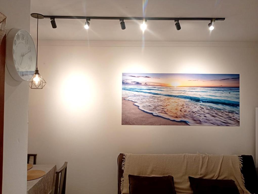 Ein Zimmer mit einem Bild des Meeres und Lichtern an der Wand in der Unterkunft Lindo apartamento! 2 quartos com suíte, churrasqueira, garagem in Florianópolis