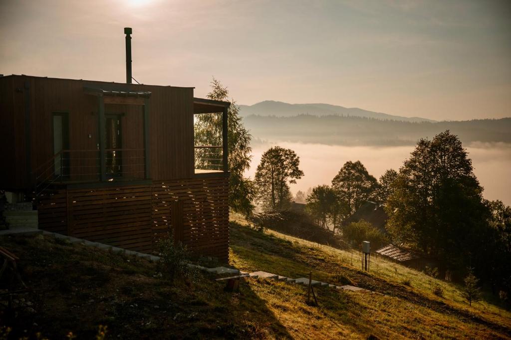 een huis op een heuvel met uitzicht op een mistig veld bij Shepit space in Slavske