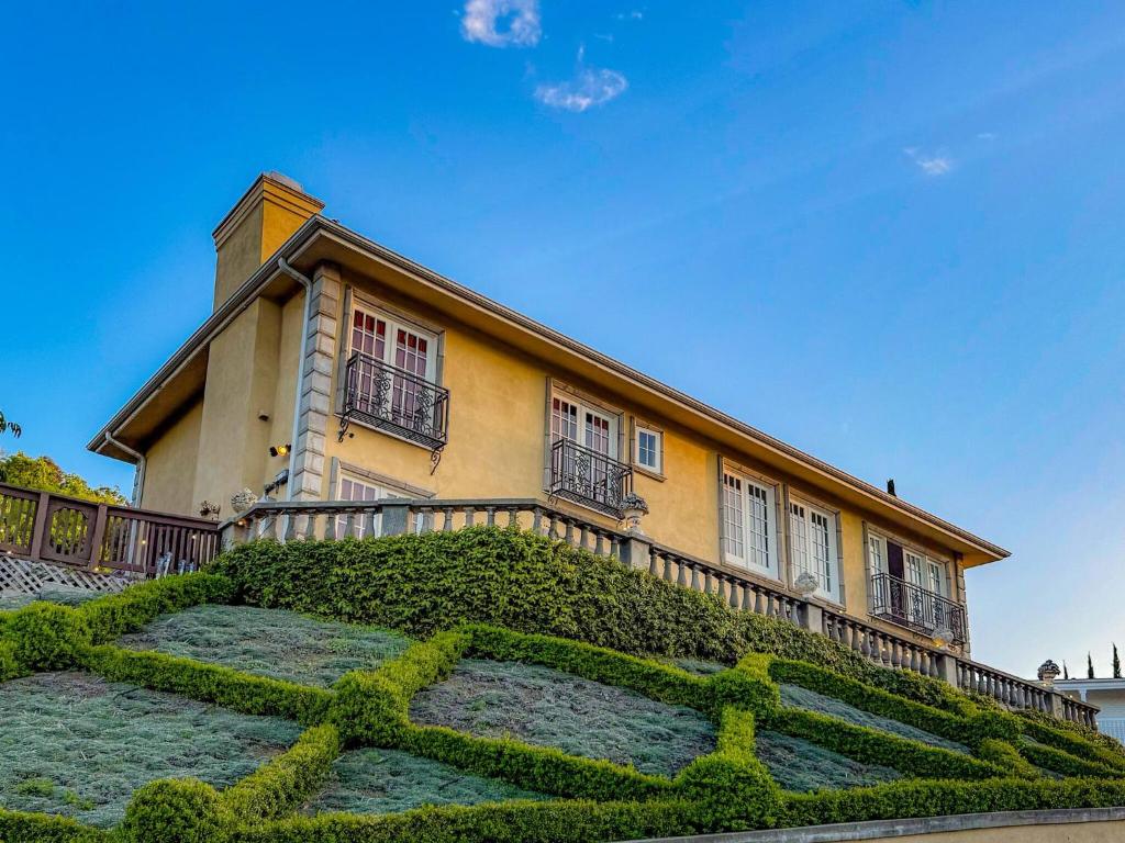 a house with a hedge in front of it at Vista Villa – Poolside Elegance with Views in Sherman Oaks