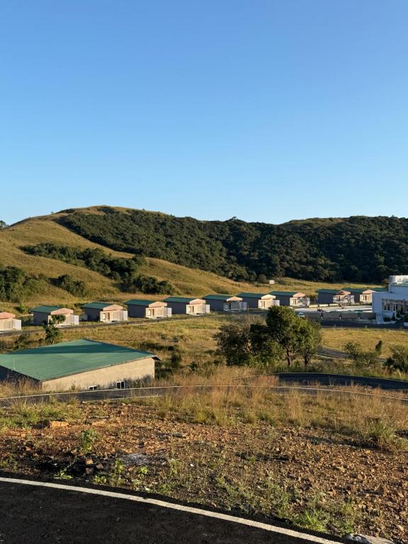 a pool in a field next to a mountain at Sacred Grove Resort Sohra in Cherrapunji