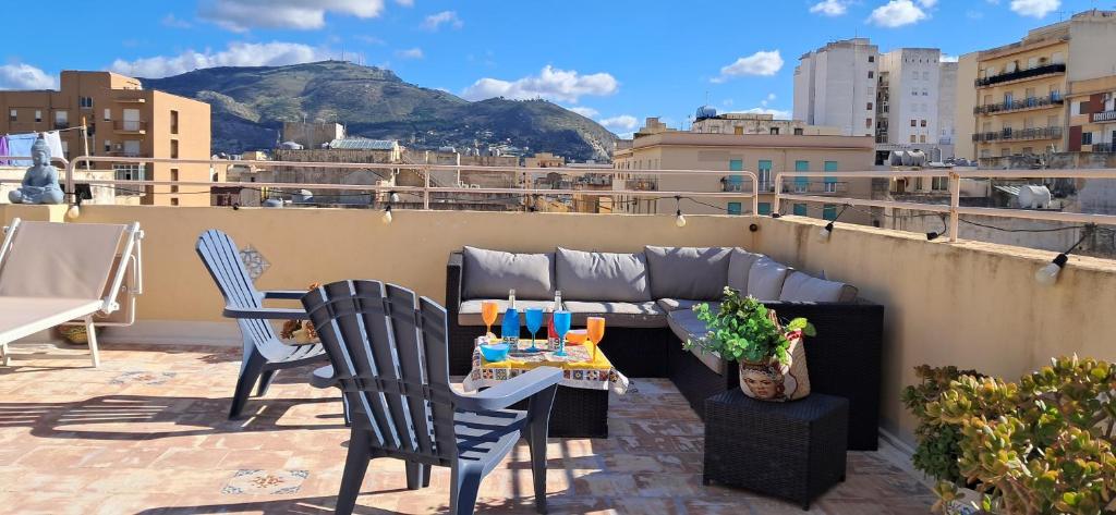a patio with a couch and chairs on a roof at LA TERRAZZA ILLUMINATA luxury ROOFTOP in Trapani