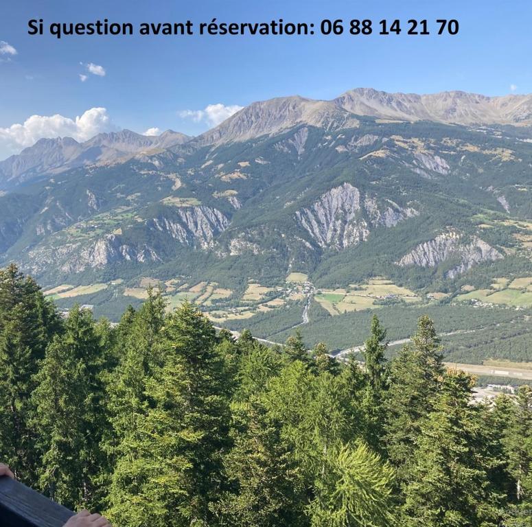 a view of a mountain range with trees in the foreground at Studio standing PRALOUP 1600 dernier étage 4 personnes Vue époustouflante in Uvernet-Fours