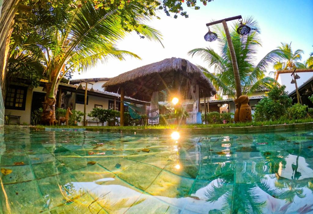 a swimming pool at a resort with palm trees at Milagres de Minas in São Miguel dos Milagres