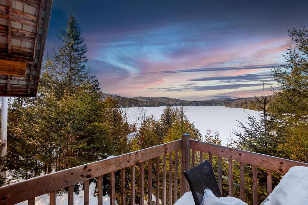 a view of a lake from the deck of a cabin at Le P'tit Bonheur - Plage avec embarcations in Sainte-Lucie-de-Doncaster