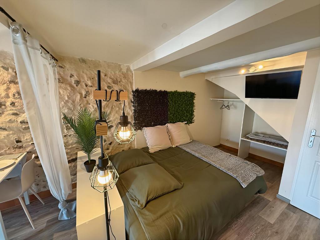 Un dormitorio con una cama verde y una escalera. en La Grotte Provençale à Sisteron, en Sisteron