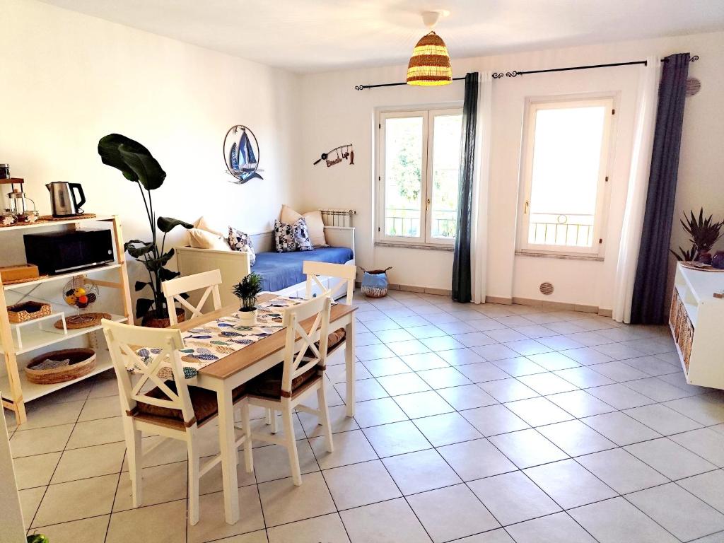 a living room with a table and chairs and a couch at Almarea Beach - Essenza del mare, calore di casa in Imperia