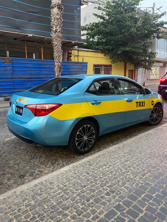 a blue and yellow car parked on a street at Taxi driver in Espargos