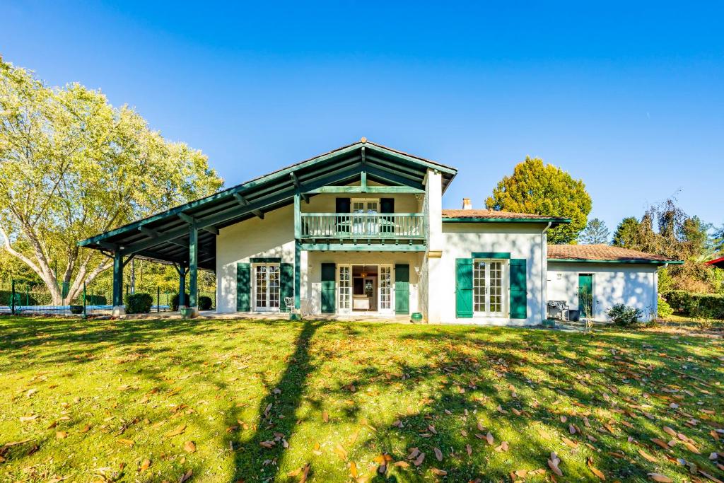 ein großes Haus auf einem Grasfeld in der Unterkunft Villa Berhartia in Cambo-les-Bains