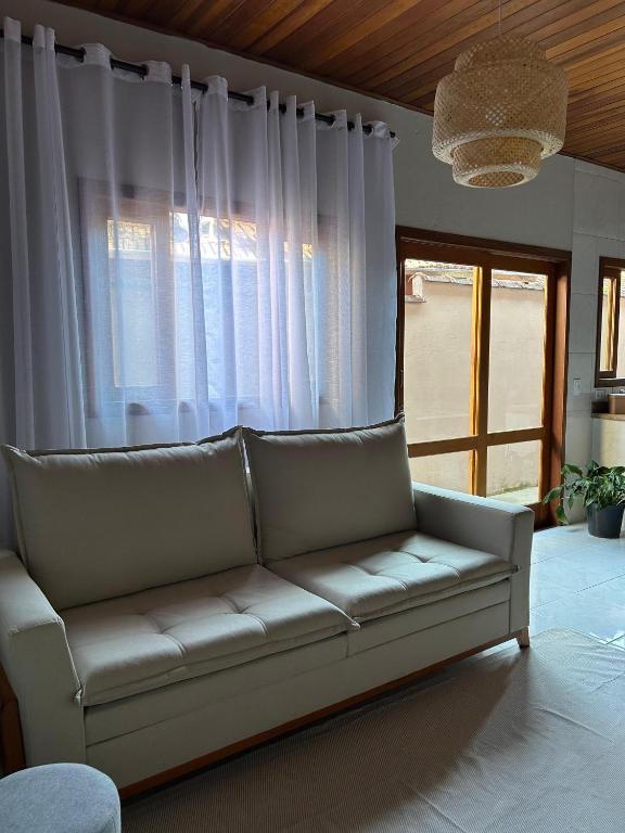 a living room with a couch in front of a window at Recanto no Centro in São Francisco Xavier