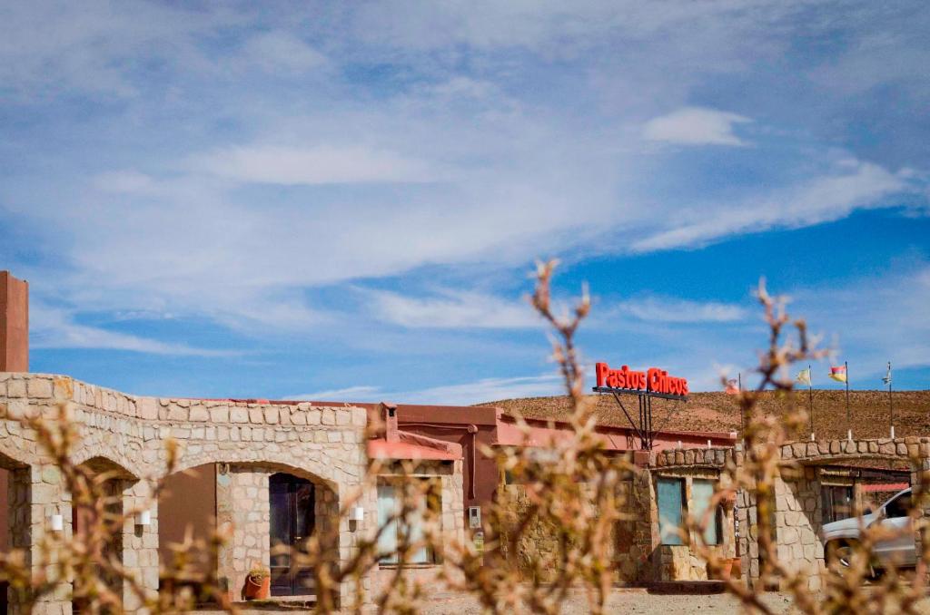 Un edificio con un cartel rojo encima. en Hotel Pastos Chicos, en Susques