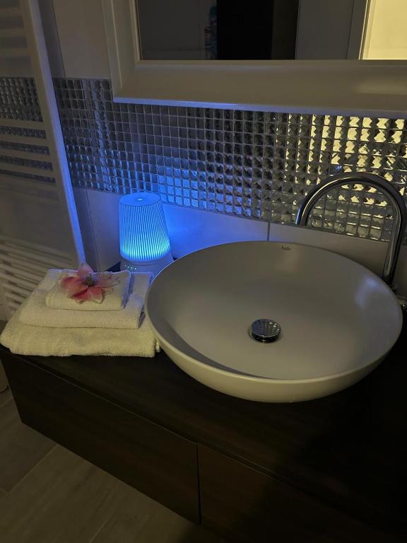 a white sink in a bathroom with a blue wall at Neue Erdgeschosswohnung in Zentrum von Rockenhausen in Rockenhausen