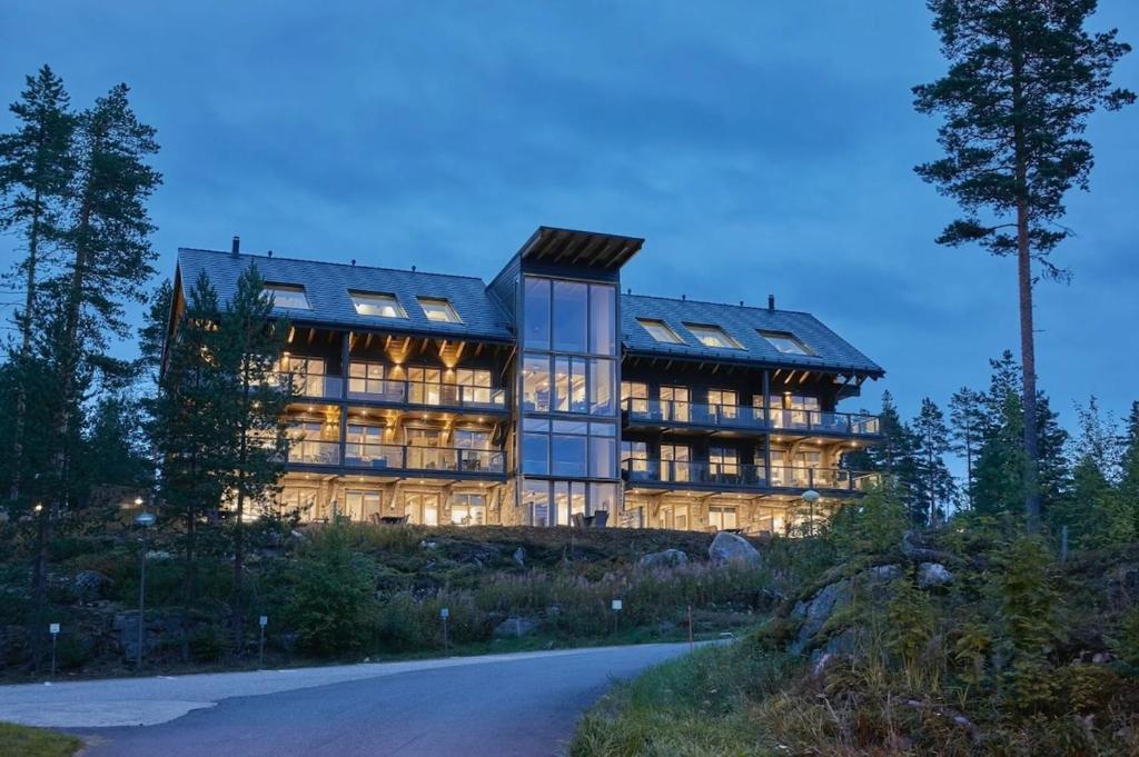 a large building with many windows on a hill at Naava Chalet Loft - Kaksikerroksinen lasiseinähuoneisto järvinäköalalla in Ähtäri