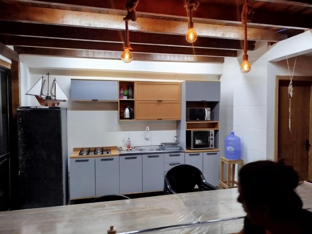 a kitchen with white cabinets and a counter top at Sobrado São Chico, Ubatuba SFS in São Francisco do Sul