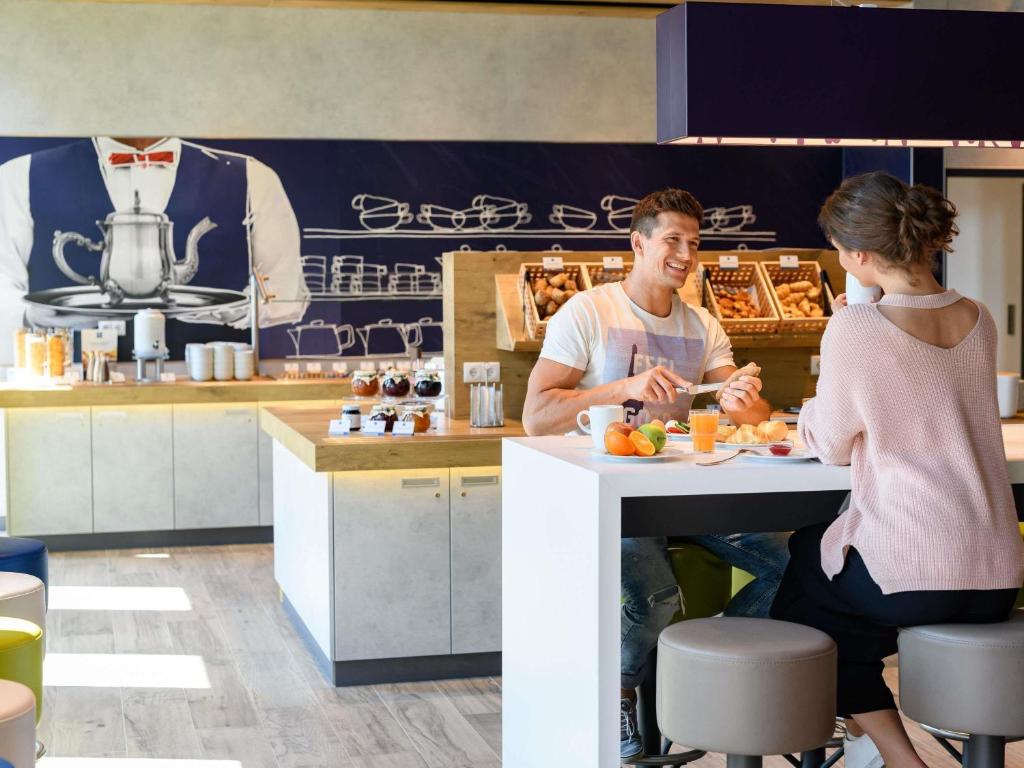 ブレーメンにあるibis budget Bremen City Centerの台所のカウンターに座る男女