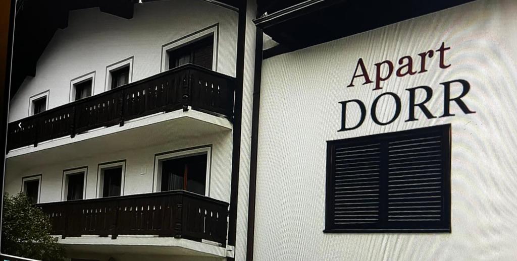 圣安东阿尔贝格Apart Dorr的一栋白色建筑，上面挂着一块牌子，写着“独立捐赠者”。