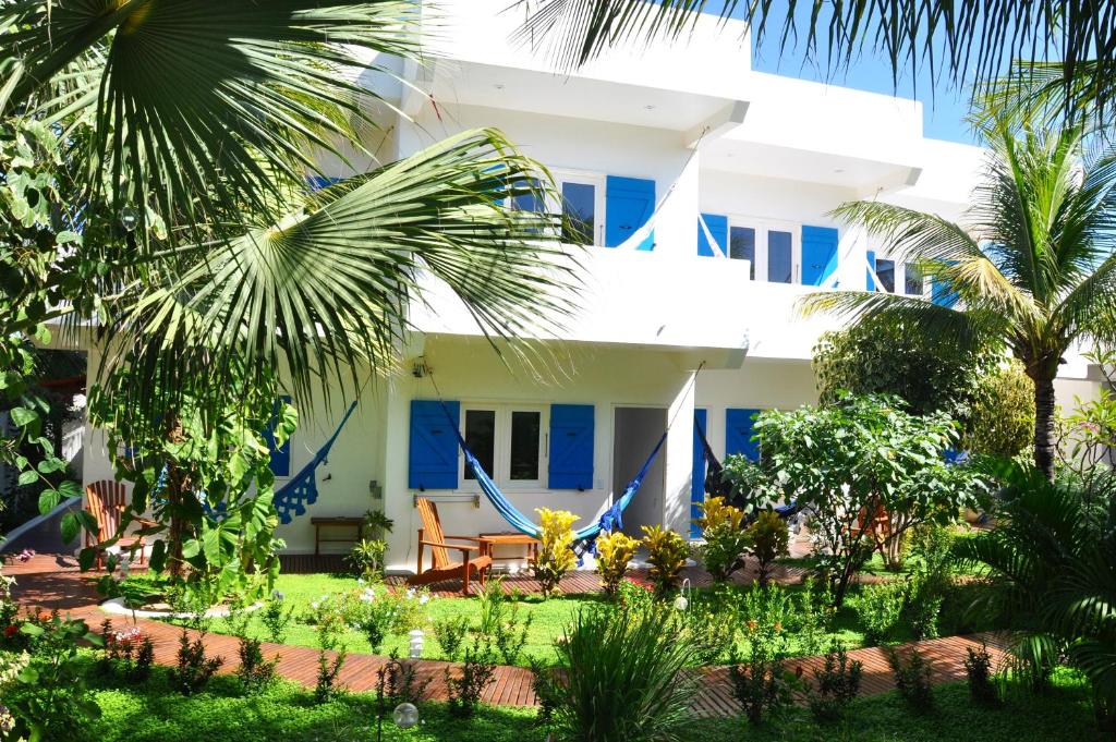 uma vista para a frente de uma casa com palmeiras em Pousada Caminho da Praia em Jericoacoara