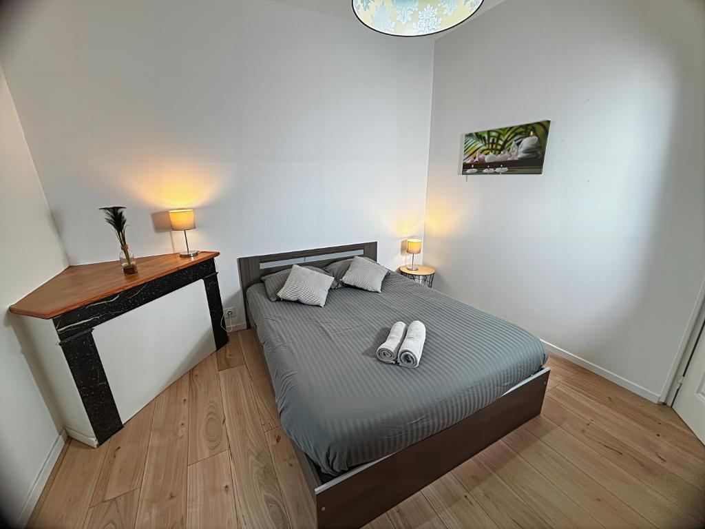 Un dormitorio con una cama con dos pantuflas encima. en Charme Médiéval à Provins, en Provins