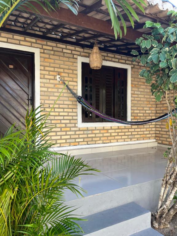 a brick house with a porch with a window at Nordestino in Pipa