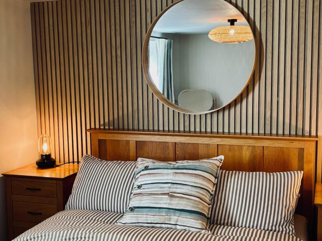 una camera da letto con un letto con uno specchio sul muro di Hanger Farmhouse Hideaway a Totton and Eling