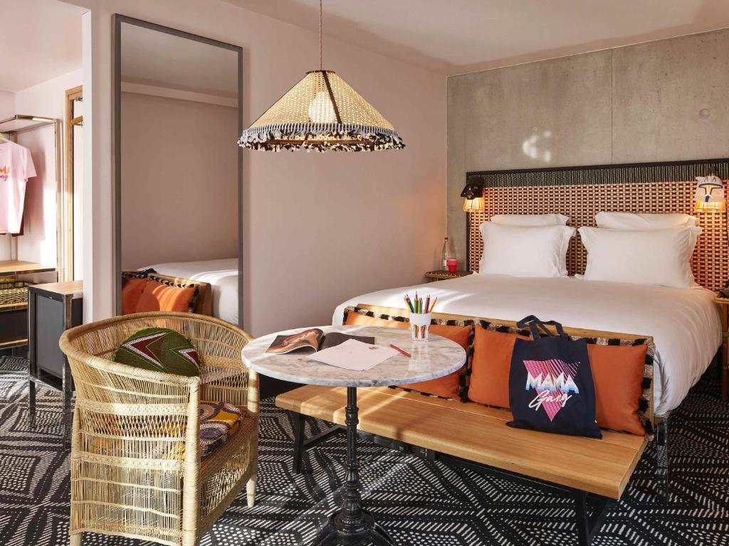 een hotelkamer met een bed, een tafel en stoelen bij Mama Shelter Paris West in Parijs
