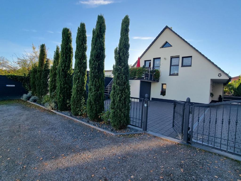 een wit huis met een hek en bomen bij Ferienwohnung im Haus Petry in Freinsheim