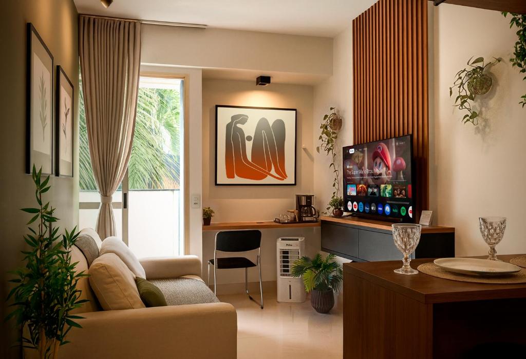 a living room with a couch and a tv at Apê super charmoso! Ar-condicionado e piscina in Brasilia