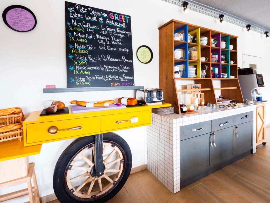 a kitchen with a yellow bike in front of a counter at greet Hotel Beaune in Beaune