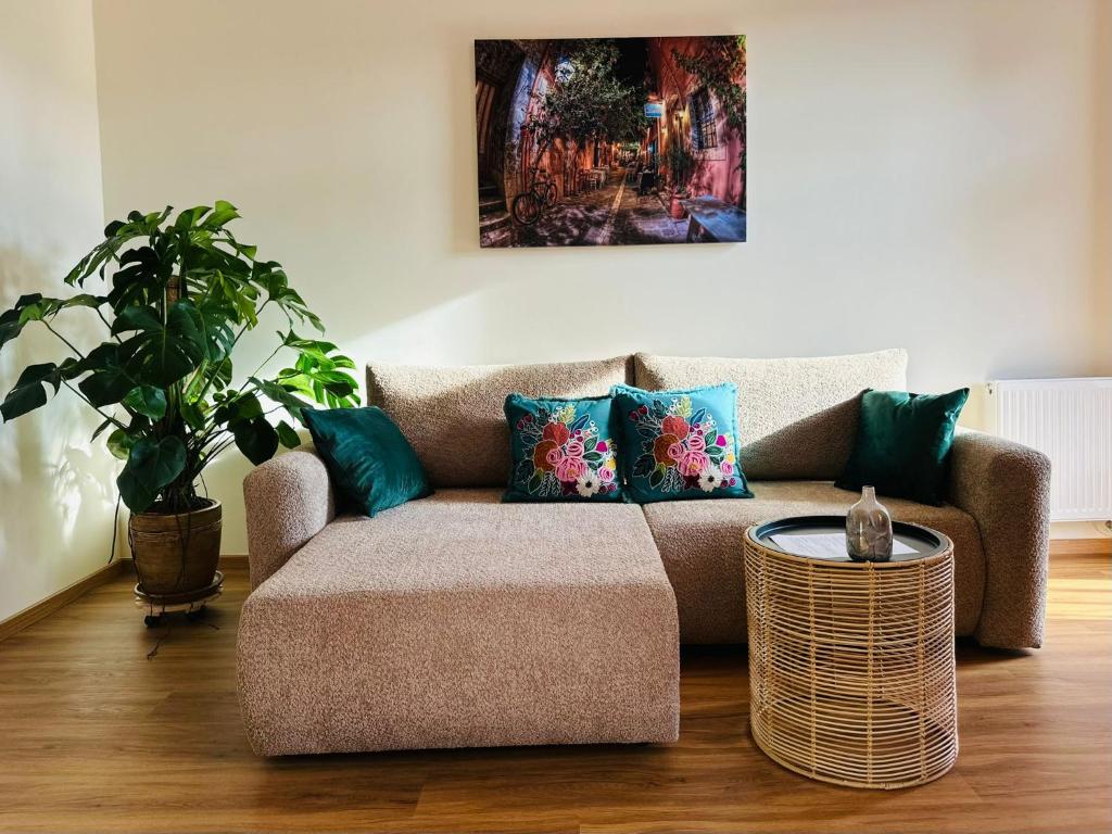 ein Wohnzimmer mit einer Couch und einer Topfpflanze in der Unterkunft Apartament Ratuszowy in Wałbrzych