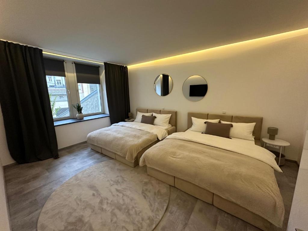 a bedroom with two beds and a large window at Good Vibes Luxury Homes in Kaiserslautern
