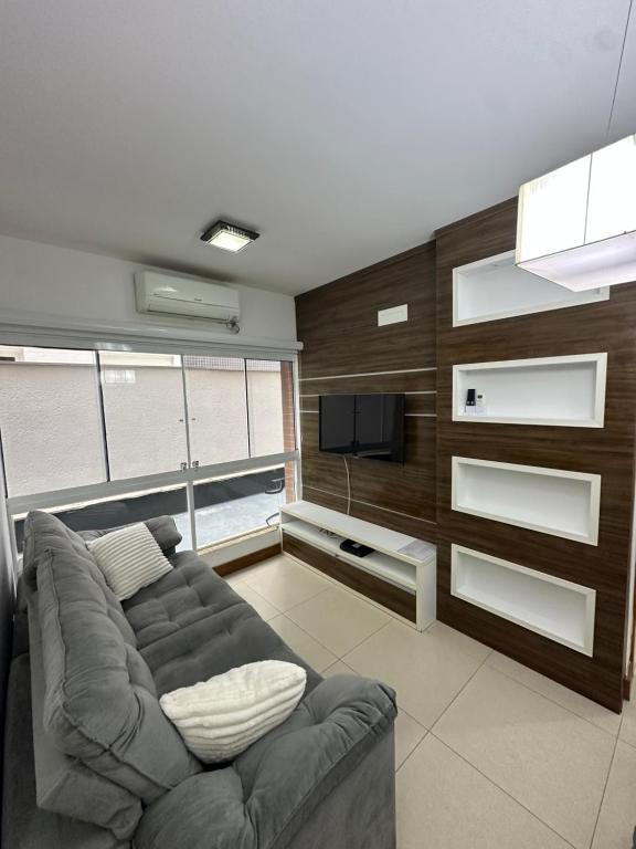 ein Wohnzimmer mit Couch und Flachbildfernseher in der Unterkunft Melhor apartamento de capão! 100m da praia in Capão da Canoa