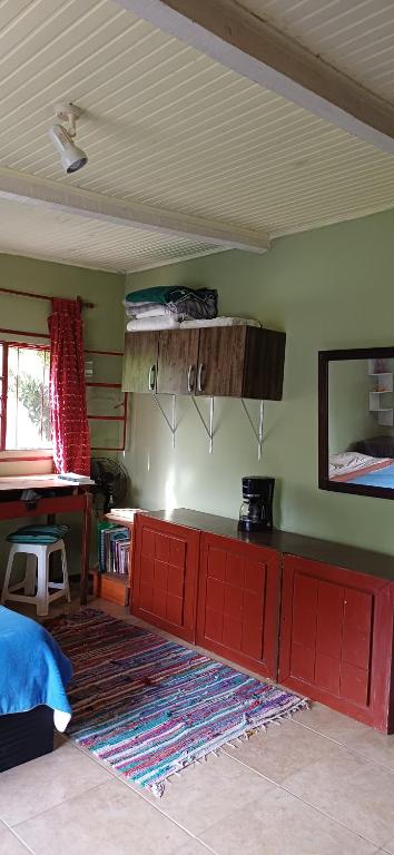 ein Wohnzimmer mit einem roten Schrank und einem Teppich in der Unterkunft Puka ra in Colonia del Sacramento