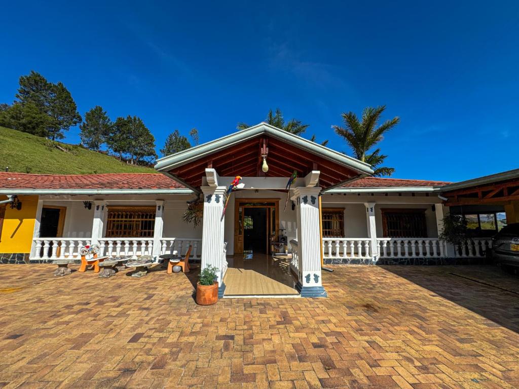 ein Haus mit einem weißen Zaun und einer Veranda in der Unterkunft Casa Finca Villa Laura 158 in Rionegro