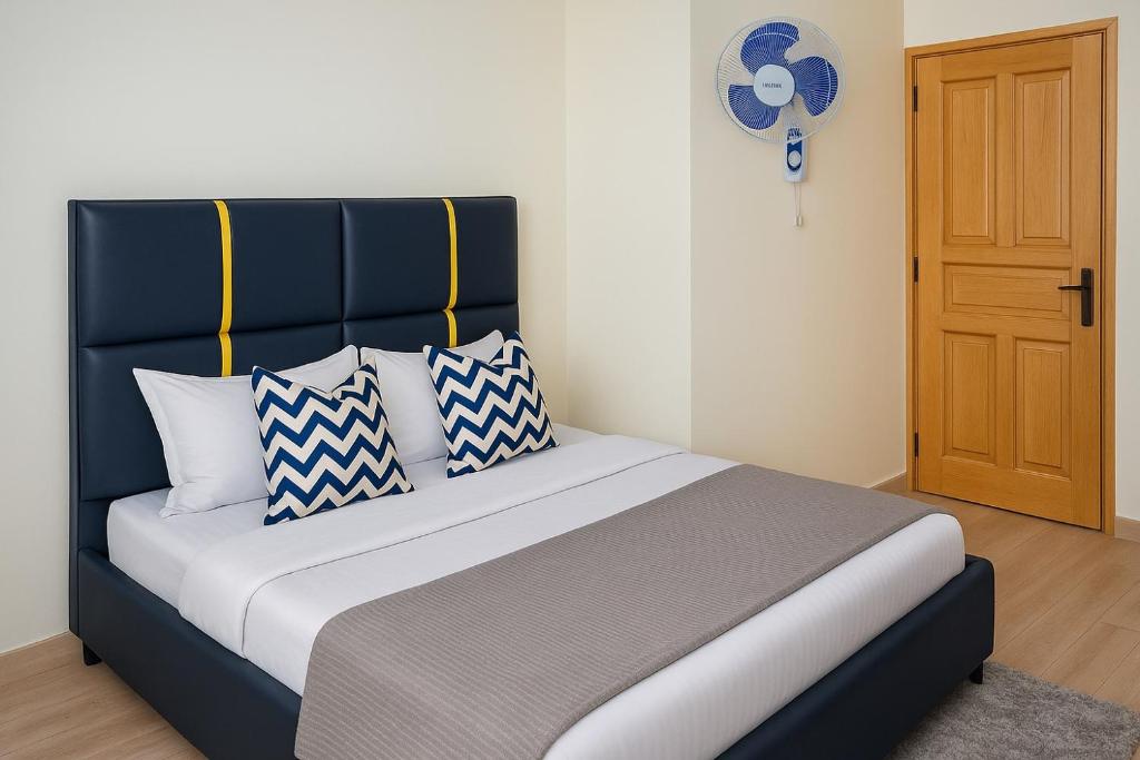 a bed with blue and white pillows in a room at Noaz Hotel in Bulambiro