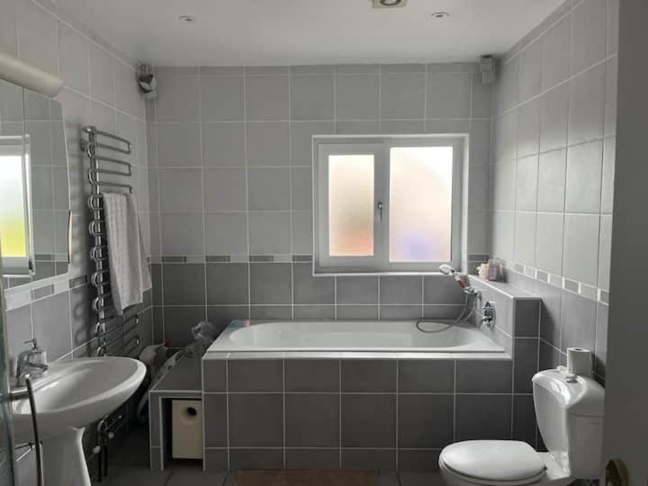 a bathroom with a tub and a toilet and a sink at Clonkellure house in Kilbrittain