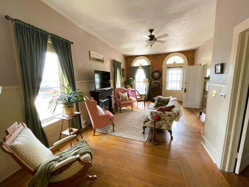 een woonkamer met meubilair en een groot raam bij Historic Victorian Apartment in McGregor