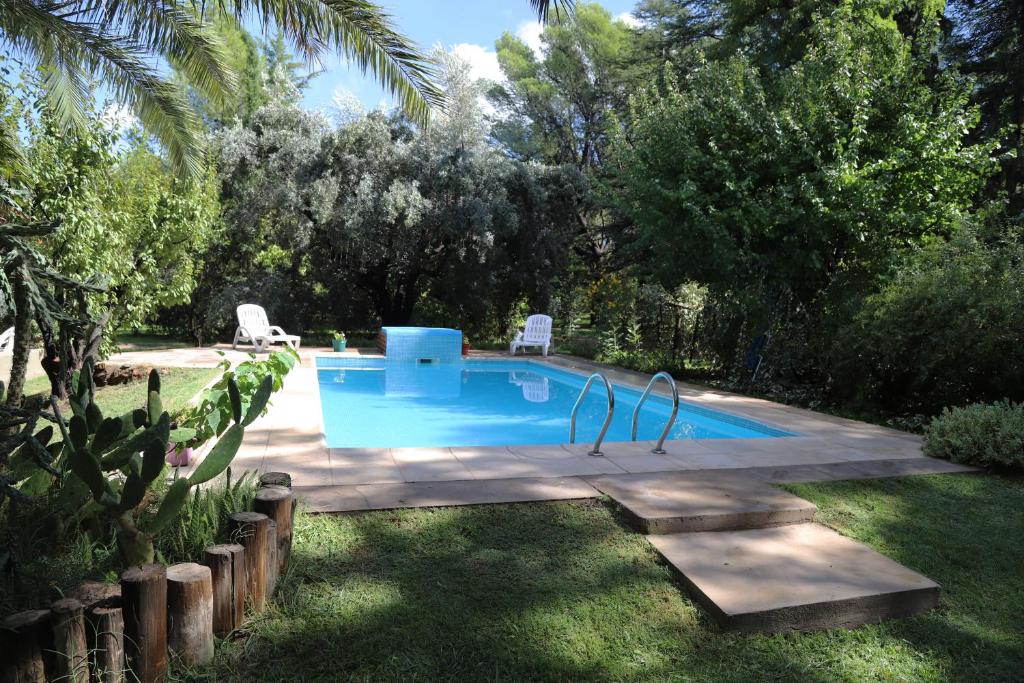 a swimming pool in a yard with two chairs and trees at Escapada Exclusiva en Finca con Viñedos y Olivares Relájate en la Naturaleza con Confort y Encanto in San Rafael